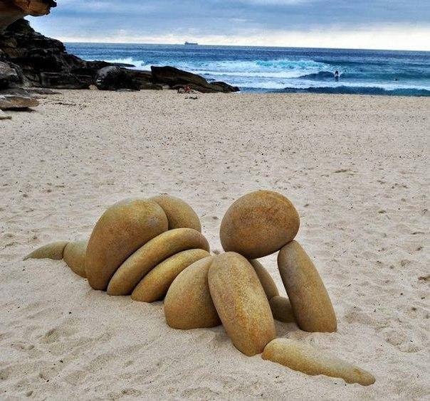 Land'art sur sable corps de Femme opulente en galets