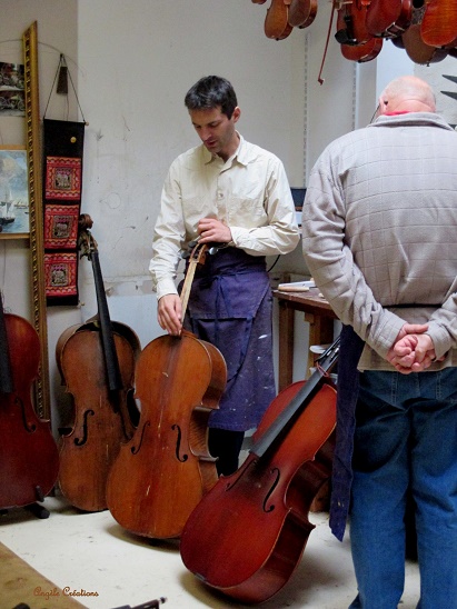 Guillaume examinant un violoncelle avec Michel , un passionné en stage!