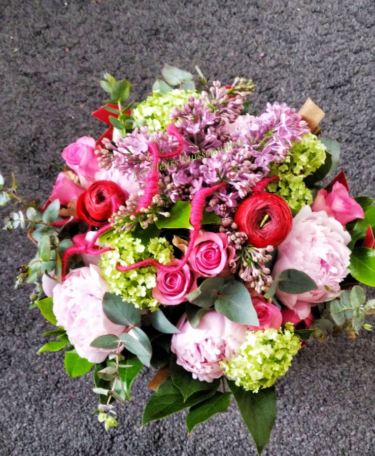 Bouquet rond "Gourmandise" aux couleurs de fruits rouges! Un mélange de renoncules, de roses et autres fleurs de saison (lilas, hortensia, pivoines....)
